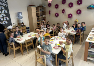 Dzieci siedzą przy stoliku i wspólnie świętują