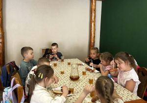 przedszkolaki jedzą kiełbaski z grilla
