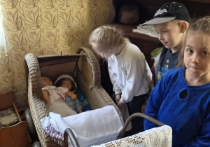 dziewczynka zagląda do wózka z lalką
