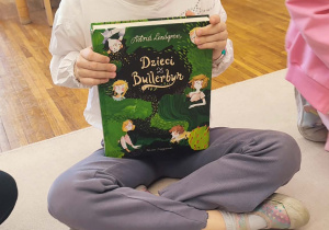 Dziewczynka z książką ,, Dzieci z Bullerbyn''