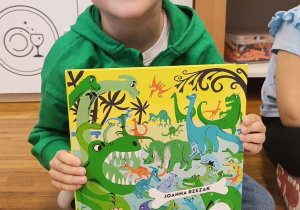 Chłopiec z książką o dinozaurach