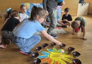 Dziewczynka rozkłada koraliki a chłopiec trzyma globus
