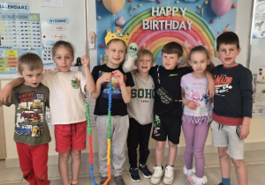 Szymonek pozuje z kolegami i koleżankami oraz trzyma linię życia