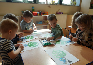 dzieci wylepiają drzewa plasteliną