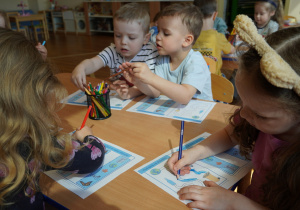 dzieci wykonują karty pracy