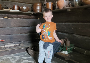 chłopiec pokazuje gliniane naczynia