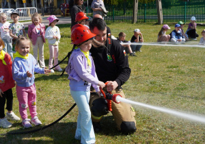 dzieci leją wodą na pachołki