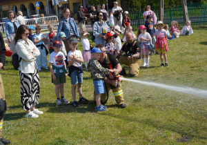dzieci leją wodą na pachołki
