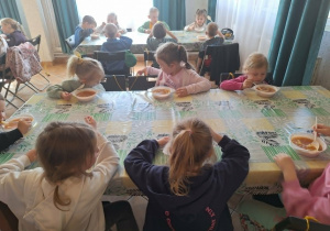 dzieci jedzą zupę