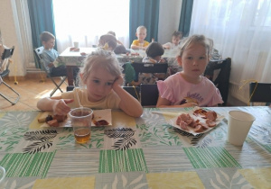 dzieci jedzą kiełbaskę
