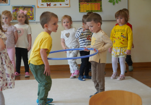 chłopcy niosą hula hop