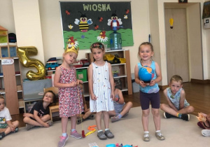 dzieci chodzą wokół urodzinowego słoneczka