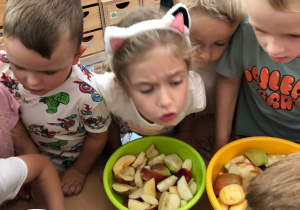 dzieci wrzucają do termomixa kawałki jabłek i uważnie obserwują