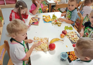 przedszkolaki kroją owoce na kawałki