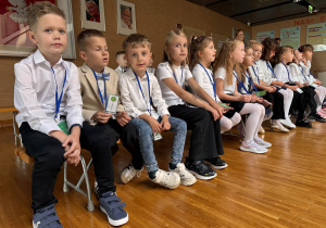 dzieci siedzą na ławce i pozują do zdjęcia
