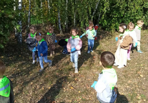dzieci zbierają śmieci w lesie