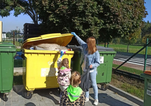 dziewczynki wrzucają śmieci do kosza