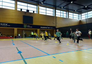 Dzieci biegają po hali sportowej