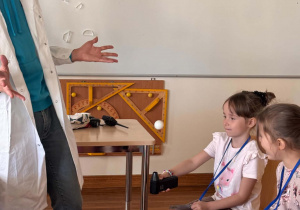 dziewczynka wykonuje eksperymet z latająca piłeczką