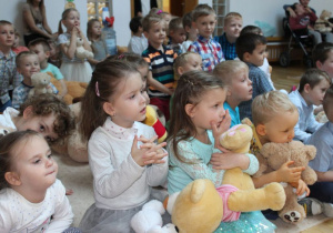 Dzieci siedzą z misiami 