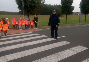 dzieciaki przechodzą przez pasy z panem policjantem