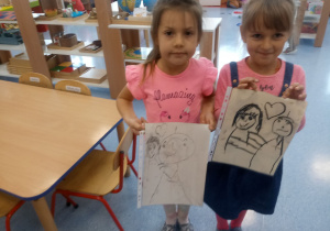 2 dziewczynki pokazują swoje prace