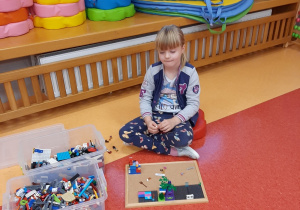 dziewczynka buduje z Lego