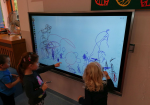 Dzieci rysują na tablicy multimedialnej
