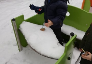 Chłopiec kładzie przysmak dla ptaków na śniegu