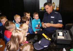 Dzieci poznają wyposażenie policjanta .