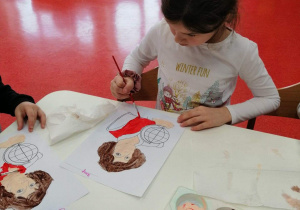 dziewczynka maluje portret Mikołaja Kopernika