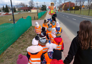 Dzieci idą z Marzanną ulicami Łuszczanowic