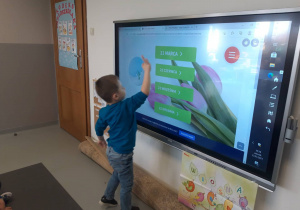 Chłopiec rozwiazuje zadanie na tablicy interaktywnej