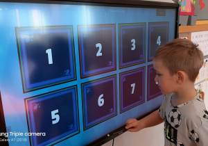 chłopiec używa tablicy interaktywnej