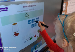 dziewczynka używa tablicy interaktywnej