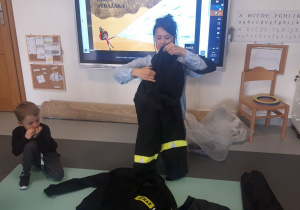 Dzieci ogladają mundur strażacki