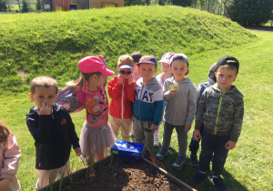 Dzieci stoją obok ogródka