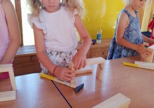 dziewczynka składa drewniane elementy