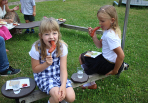 dziewczynki jedzą kiełbaskę