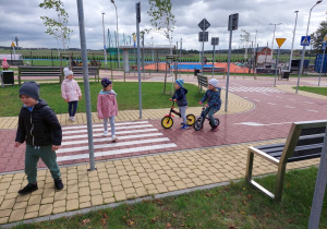 dzieci poruszają się po miasteczku rowerkami