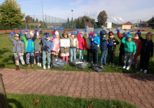 grupowe zdjęcie i prezentacja posprzątanych i posegregowanych śmieci