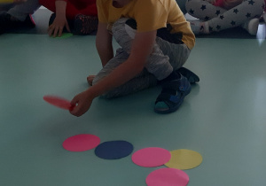 Chłopiec dokłada kolorowa kropke