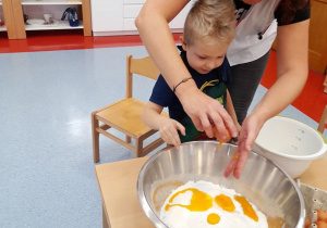 Pani Madzia pomaga chłopcu wbić jajko
