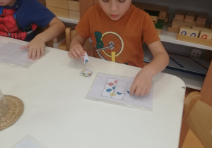 chłopiec układa układankę z figur