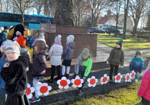 6-latki wbijają w ziemię biało- czerwone kwiaty1