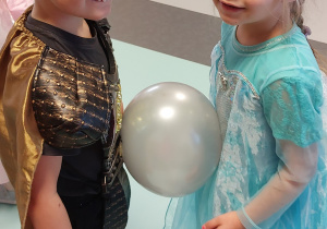 Chłopiec i dziewczynka tańczą z balonem