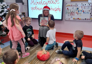 Pani bibliotekarka pokazuje przyniesione książki