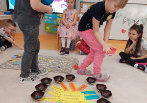 dziewczynka rozkłada koraliki a chłopiec chodzi z globusem