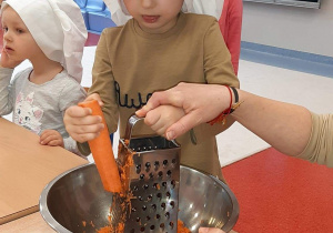 chłopiec trze marchewkę