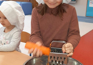dziewczynka trze marchewkę